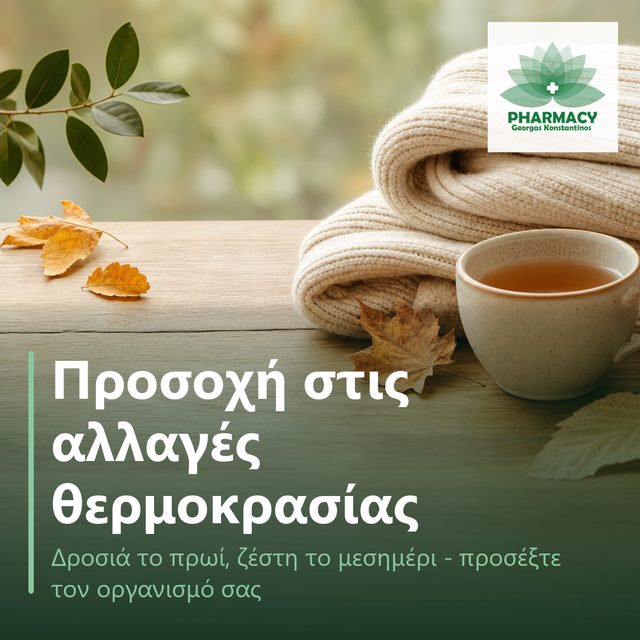 Ένα πλεκτό ζακετάκι δίπλα σε ένα ζεστό ρόφημα πάνω σε ξύλινη επιφάνεια, με λίγα φθινοπωρινά φύλλα, σε ήρεμη σύνθεση με ζεστούς τόνους.