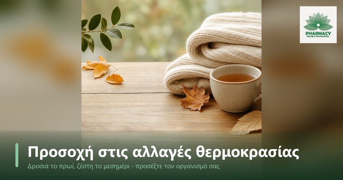 Ένα πλεκτό ζακετάκι δίπλα σε ένα ζεστό ρόφημα πάνω σε ξύλινη επιφάνεια, με λίγα φθινοπωρινά φύλλα, σε ήρεμη σύνθεση με ζεστούς τόνους.