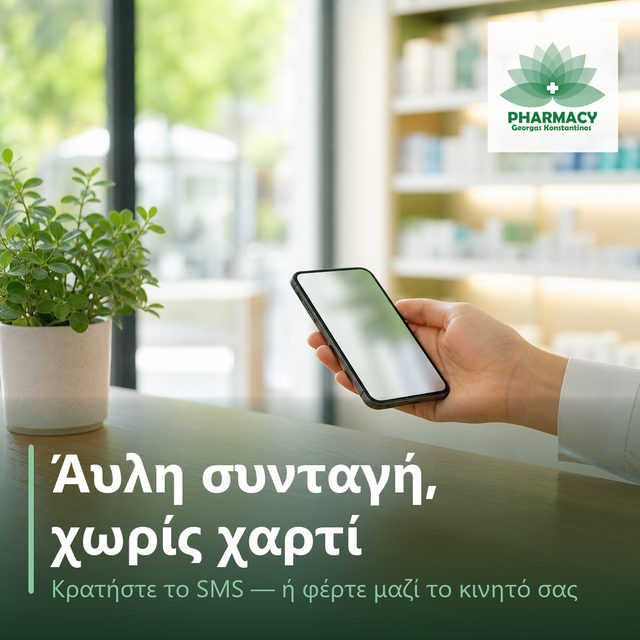 Χέρι κρατά κινητό τηλέφωνο πάνω από ξύλινο πάγκο φαρμακείου, δίπλα σε μικρό πράσινο φυτό.