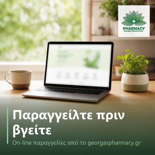 Λάπτοπ με απαλά θολή πράσινη οθόνη σε ξύλινο τραπέζι δίπλα σε καφέ και φυτό, πρωινό φως.